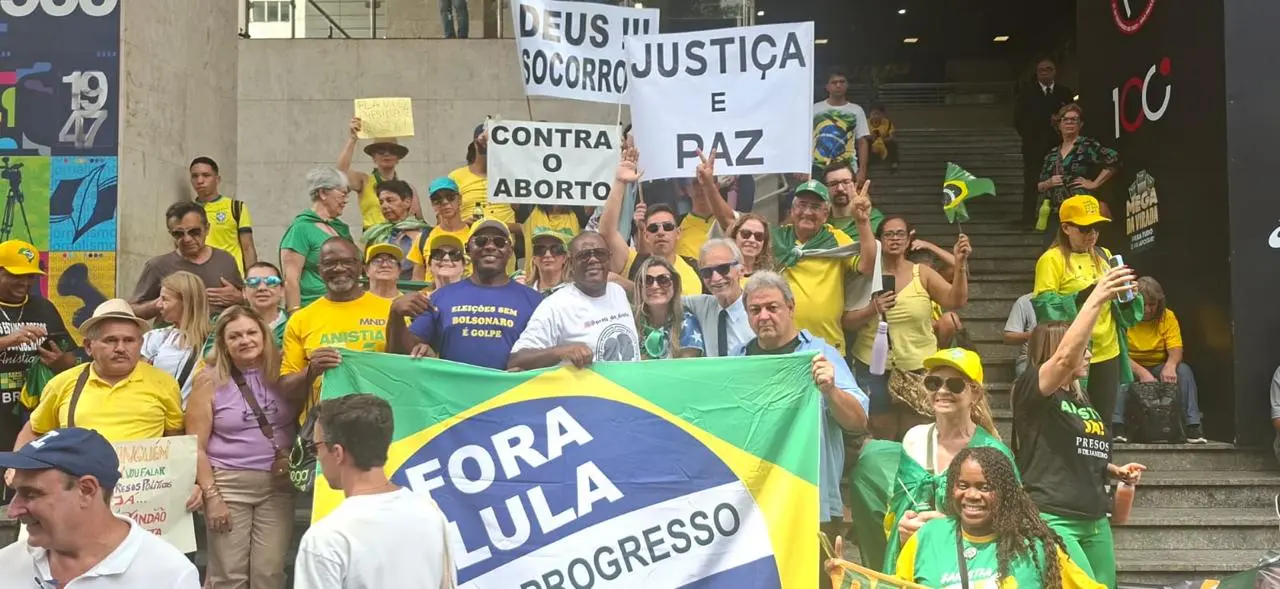 Cláudio Dias em manifestação na Avenida Paulista, segurando bandeira do Brasil.